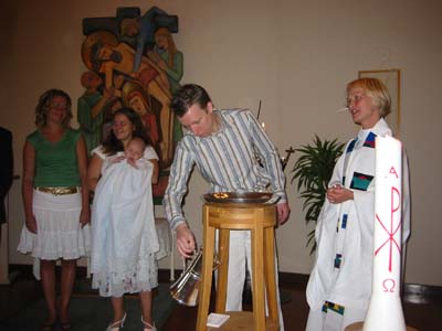 Pappa h&auml;ller vatten i dopfunten. 